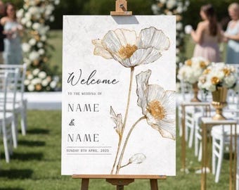 Puede incluir: Un caballete de madera exhibe un letrero de bienvenida de boda con ilustraciones florales. El letrero dice "Bienvenida" encima de los nombres y la fecha de la boda. El fondo presenta un arco floral y los invitados.
