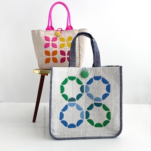 May include: Two tote bags with colorful geometric designs. One bag has a pink handle and a yellow charm, the other has a blue handle and a green charm. The text "WELL-ROUNDED TOTE + SOFTIES TEMPLATES" is at the bottom.