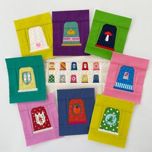 May include: A set of 10 colorful fabric squares with various embroidered designs. Each square features a different design, including a crown, a mushroom, a bird, and a frog. The squares are arranged in a circle on a white background.