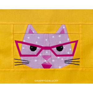 Könnte beinhalten: Ein pinkfarbenes Katzen Gesicht mit weißen Sternen und schwarzen Augen, das eine pinkfarbene Brille trägt, vor einem gelben Hintergrund. Der Text "@HAPPYSEWLUCKY" befindet sich am unteren Rand des Bildes.