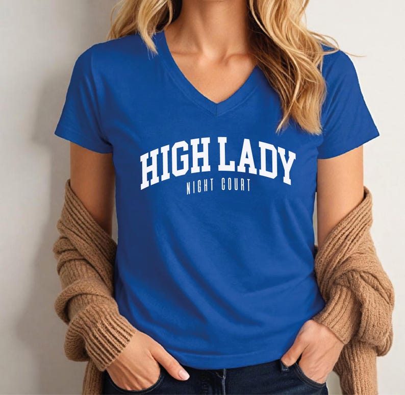 A woman wearing a blue t-shirt with the text "HIGH LADY NIGHT COURT" printed on it.