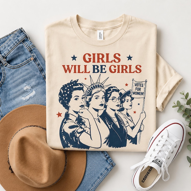 a casual outfit consisting of a beige t-shirt with a graphic design, a pair of blue jeans, a brown hat, and a pair of white sneakers.
