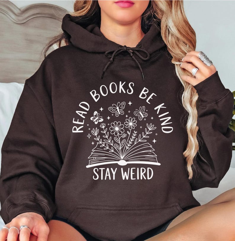 A woman wearing a black hoodie with a white graphic design and text printed on it.