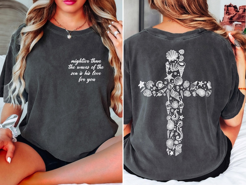 The image is a collage of two photos. In the first photo, a woman is sitting on a bed with her legs crossed, wearing a gray t-shirt with a cross design and text on the back. In the second photo, the woman is sitting on the bed, wearing the same gray t-shirt with the same cross design and text on the back.