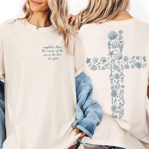 Two women wearing white t-shirts with a graphic design on the back.