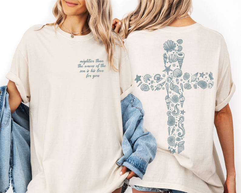 Two women wearing white t-shirts with a graphic design on the back.