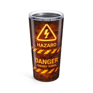 May include: A stainless steel travel tumbler with a black lid. The tumbler features a hazard warning design with the words "HAZARD", "DANGER", and "ENERGY SURGE" in yellow and orange against a dark, textured background.