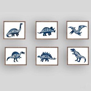 Może przedstawiać: Sześć oprawionych wydruk&oacute;w przedstawiających niebieskie sylwetki dinozaur&oacute;w w akwareli z ich nazwami napisanymi białą czcionką. Dinozaury to Brachiosaurus, Triceratops, Pterodactyl, Spinosaurus, Stegosaurus i Tyrannosaurus Rex.