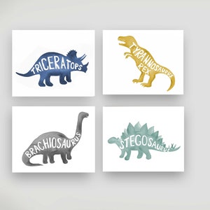 May include: Set of four watercolor dinosaur prints with the names of each dinosaur spelled out within the silhouette. The dinosaurs are a blue Triceratops, a yellow Tyrannosaurus Rex, a gray Brachiosaurus, and a green Stegosaurus.
