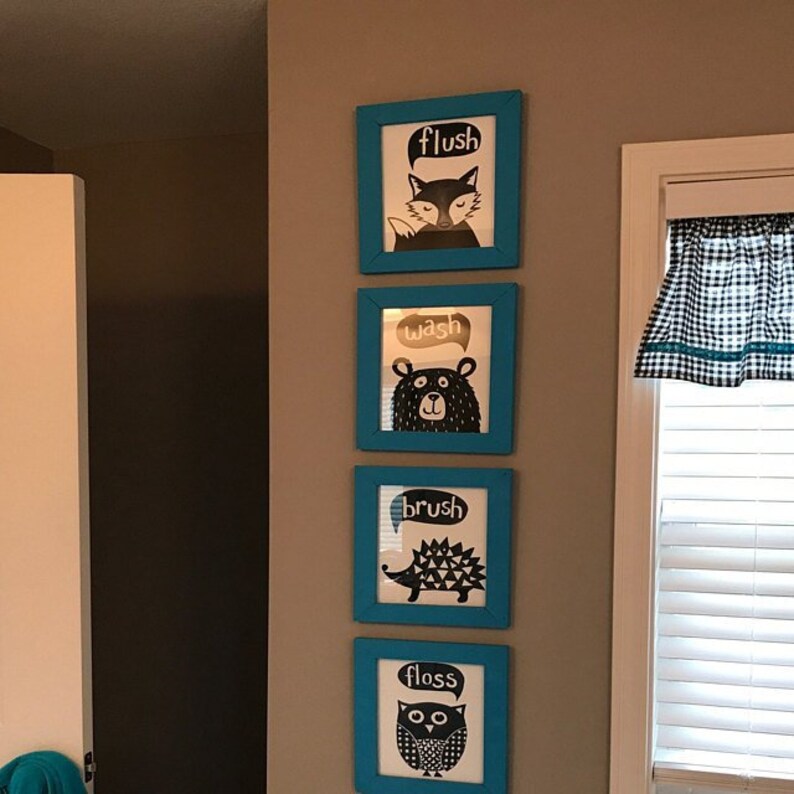 May include: Four framed prints with black and white illustrations of animals and the words "flush", "wash", "brush", and "floss" in white text. The frames are a bright teal blue.