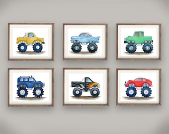 May include: Six framed watercolor illustrations of different monster trucks. The trucks are yellow, blue, green, black, red, and light blue. The trucks are all on a white background. The frames are brown wood.