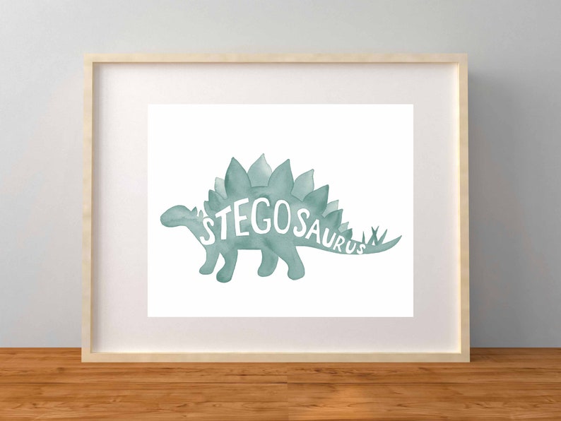 May include: A watercolor illustration of a teal green stegosaurus with the word "STEGOSAURUS" written in white inside the dinosaur's silhouette.