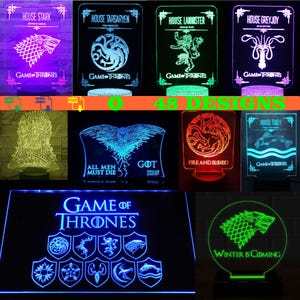Puede incluir: Colección de luces nocturnas LED con diseños de la serie Juego de Tronos. Las luces muestran varios símbolos de casas y citas, incluyendo Casa Stark, Targaryen, Lannister y Greyjoy. Cada luz tiene un color único.
