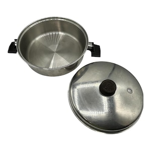 May include: Stainless steel cooking pot with a matching lid. The pot has two black handles and a shiny interior. The lid has a black knob and a small vent hole. The pot and lid are set against a white background.