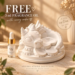 May include: A white concrete aroma stone diffuser shaped like a sleeping dragon resting on a pile of coins, accompanied by a small glass bottle of 3 ml fragrance oil. The text reads FREE 3 ml FRAGRANCE OIL with every order, A little extra for you, and AROMA STONE DIFFUSER HANDMADE WITH LOVE.