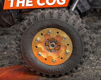 Può includere: Primo piano di uno pneumatico nero con una ruota a forma di ingranaggio dorata e color rame. Lo pneumatico ha un disegno del battistrada robusto. Il testo sull'immagine recita "THE COG" e "Designed around Injora ModuWheel 1.0".