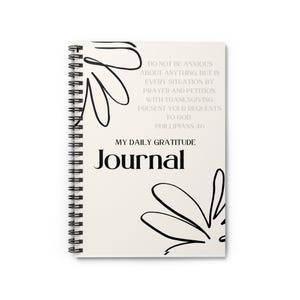 Könnte beinhalten: Ein spiralgebundenes Notizbuch mit cremefarbenem Einband. Der Einband zeigt schwarze florale Linienkunst und die Worte "MY DAILY GRATITUDE Journal". Der Text auf dem Einband lautet: "SEID UM NICHTS BEKÜMMERT, SONDERN IN ALLEN DINGEN LASST EURE BITTEN DURCH GEBET UND FLEHEN MIT DANKBARKEIT VOR GOTT KUND WERDEN."