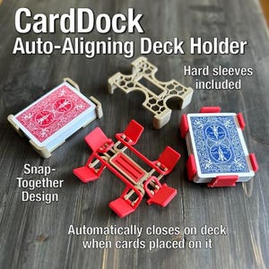 May include: A product shot of the CardDock Auto-Aligning Deck Holder. The image shows the deck holder in various stages, with text that reads "Hard sleeves included" and "Snap-Together Design". The deck holder automatically closes on the deck when cards are placed on it.