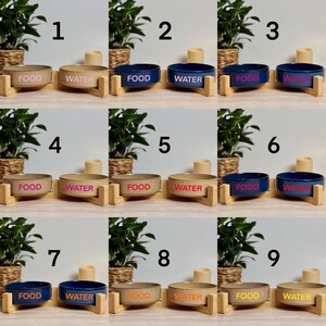 May include: A set of nine ceramic pet bowls in various colors, each labeled for food or water. The bowls are set on wooden stands. The bowls are in shades of tan and navy blue, with the text in pink and orange.
