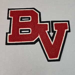 May include: A red and black letterman jacket patch featuring the letters "BV". The letters are red with a textured surface, outlined in white and black. The patch is likely for a school or team.