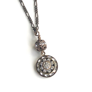 Art deco styled necklace with antique brass figaro chain with a Swarovski clear crystal ball attached to a 15mm brilliant Swarovski clear crystal three tiered disc with one large Swarovski crystal in the center. Choose from 16, 18 or 20 inch chain.