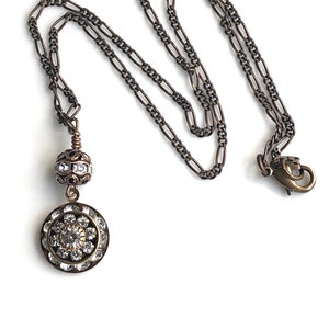 Brass art deco crystal pendant with Swarovski crystal round pendant with three tiers of Swarovski crystals suspended from a brass Swarovski crystal ball. Antique brass chain in 16, 18 or 20 inches. Lobster clasp with Nickel and lead free chain.