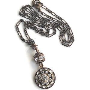 Art deco styled necklace with antique brass figaro chain with a Swarovski clear crystal ball attached to a 15mm brilliant Swarovski clear crystal three tiered disc with one large Swarovski crystal in the center. Choose from 16, 18 or 20 inch chain.