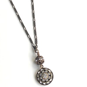 Art deco styled necklace with antique brass figaro chain with a Swarovski clear crystal ball attached to a 15mm brilliant Swarovski clear crystal three tiered disc with one large Swarovski crystal in the center. Choose from 16, 18 or 20 inch chain.