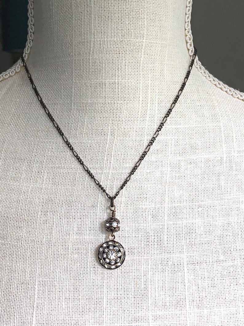 Brass art deco crystal pendant with Swarovski crystal round pendant with three tiers of Swarovski crystals suspended from a brass Swarovski crystal ball. Antique brass chain in 16, 18 or 20 inches. Lobster clasp with Nickel and lead free chain.