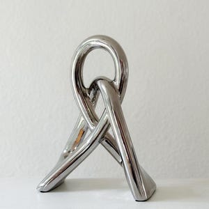 abstract minimalist interlocking ceramic chrome tie knot sculpture