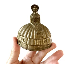 solid brass prairie girl in dress ringing bell