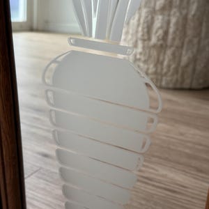 May include: A white frosted glass mirror with a white etched carrot design.