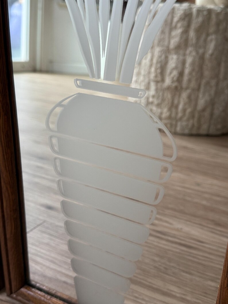 May include: A white frosted glass mirror with a white etched carrot design.