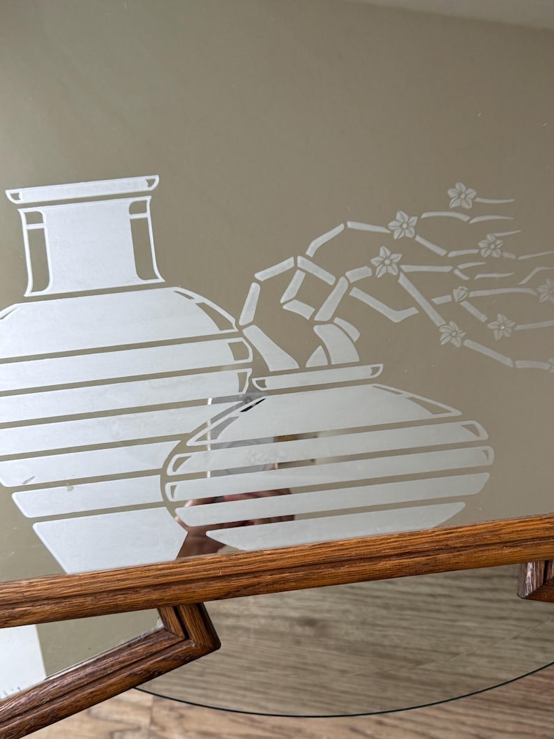 May include: A mirrored tray with a wooden frame features an etched design of two vases and a flowering branch. The vases are striped and the branch has delicate flowers.