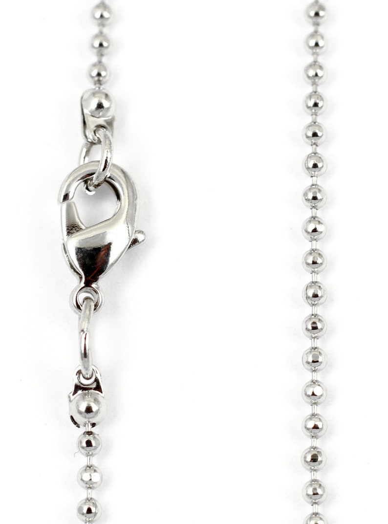 May include: A silver ball chain necklace with a lobster clasp closure.