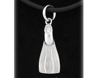 May include: A silver-colored pendant shaped like a diving fin, suspended from a black cord. The fin has detailed ridges and is attached to a circular bail. The text "Dive4Jewelry" is visible at the bottom right.