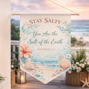 Könnte beinhalten: Ein Wandbehang mit Strandmotiv und dem Text "Stay Salty, You Are the Salt of the Earth, Matthew 5:13." Das Banner zeigt Aquarellillustrationen von Muscheln, Blumen und einer Strandszene.