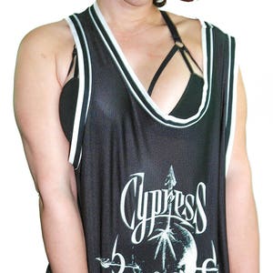 May include: Black basketball jersey with white trim and a skull graphic with the text "Cypress Hill" printed on the front.