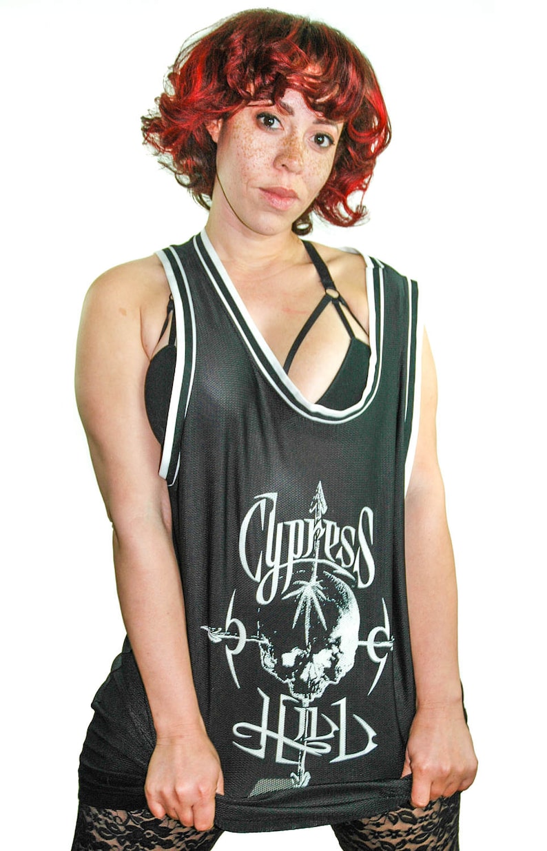 May include: Black sleeveless tank top with a white and black striped trim. The tank top features a white graphic of a skull with an arrow and the text "Cypress Hill".