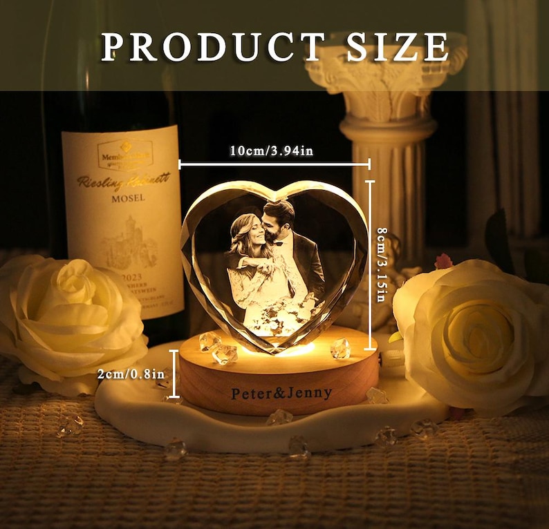 May include: A heart-shaped crystal block featuring an engraved photograph of a couple, mounted on a round wooden base with the text "Peter & Jenny" printed on the front. The crystal measures 3.94 inches wide by 3.15 inches high, with a 0.8 inch base.
