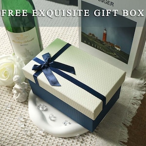 May include: A rectangular gift box with a textured cream lid and a dark blue base, featuring a dark blue satin ribbon tied in a bow on top. The text "FREE EXQUISITE GIFT BOX" is printed in white across the top portion of the image.