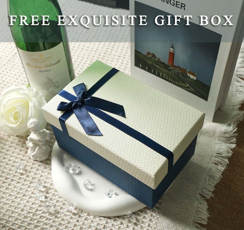 May include: A rectangular gift box with a textured cream lid and a dark blue base, featuring a dark blue satin ribbon tied in a bow on top. The text "FREE EXQUISITE GIFT BOX" is printed in white across the top portion of the image.