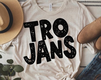 May include: A beige t-shirt with the word "TROJANS" printed in black distressed lettering.