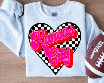 Może przedstawiać: Szara bluza z nadrukiem "Kansas City" w kolorze różowym i czerwonym w kształcie serca w kratkę.