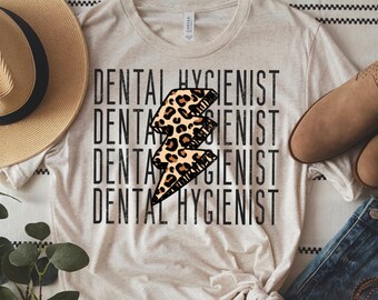 May include: A beige t-shirt with the text "Dental Hygienist" repeated four times in black. A leopard print lightning bolt graphic is centered on the shirt.