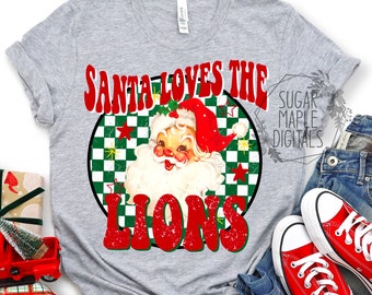 May include: A gray t-shirt with a red and green circle design featuring a cartoon Santa Claus and the text "Santa Loves The Lions".