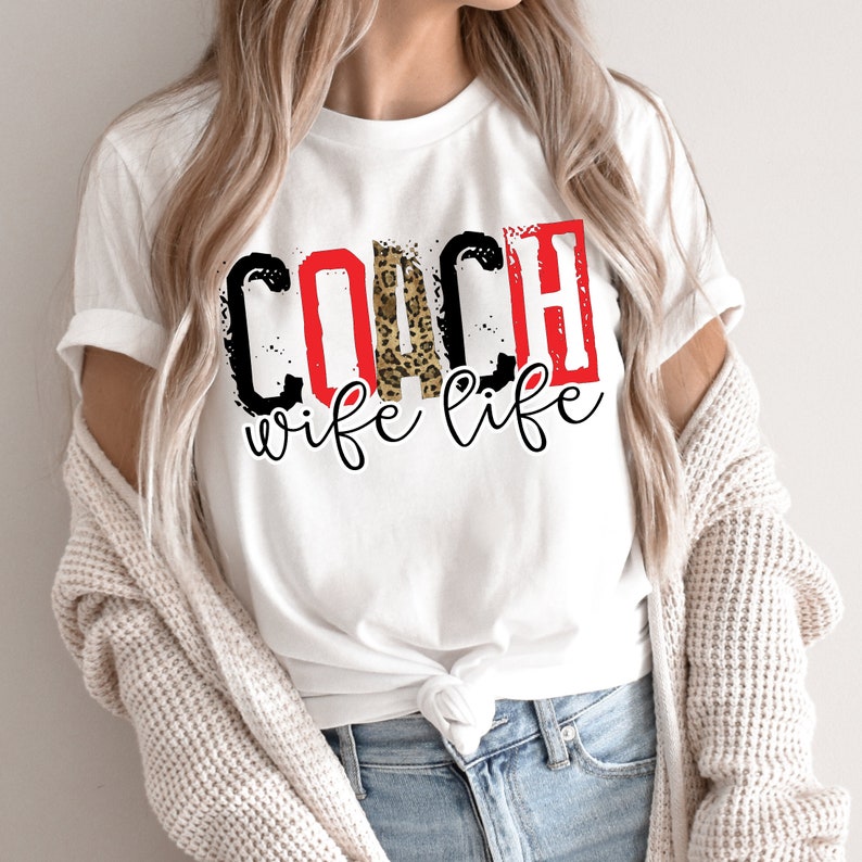 Peut inclure: T-shirt blanc avec le texte "COACH wife life" en rouge, noir et imprim&eacute; l&eacute;opard.