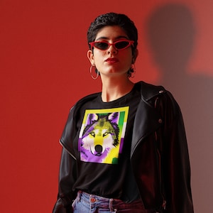 May include: A person wearing a black t-shirt with a wolf graphic in purple, yellow, and green colors. The wolf is framed by a yellow border. The person is also wearing a black leather jacket, red sunglasses, and blue jeans.