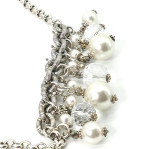 K&ouml;nnte beinhalten: Silberfarbene Halskette mit einer klobigen Kette und einer Kaskade aus Kunstperlen und facettierten, klaren Perlen. Die Halskette hat gro&szlig;e und kleine Perlen mit dekorativen Metallakzenten. Ein stilvolles Accessoire.