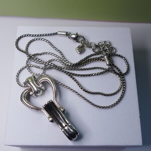 Puede incluir: Collar con colgante de llave plateada. El colgante tiene forma de llave con la parte superior en forma de coraz&oacute;n y un ca&ntilde;&oacute;n detallado. La cadena del collar es de dise&ntilde;o trenzado y delicado, con cierre de mosquet&oacute;n.